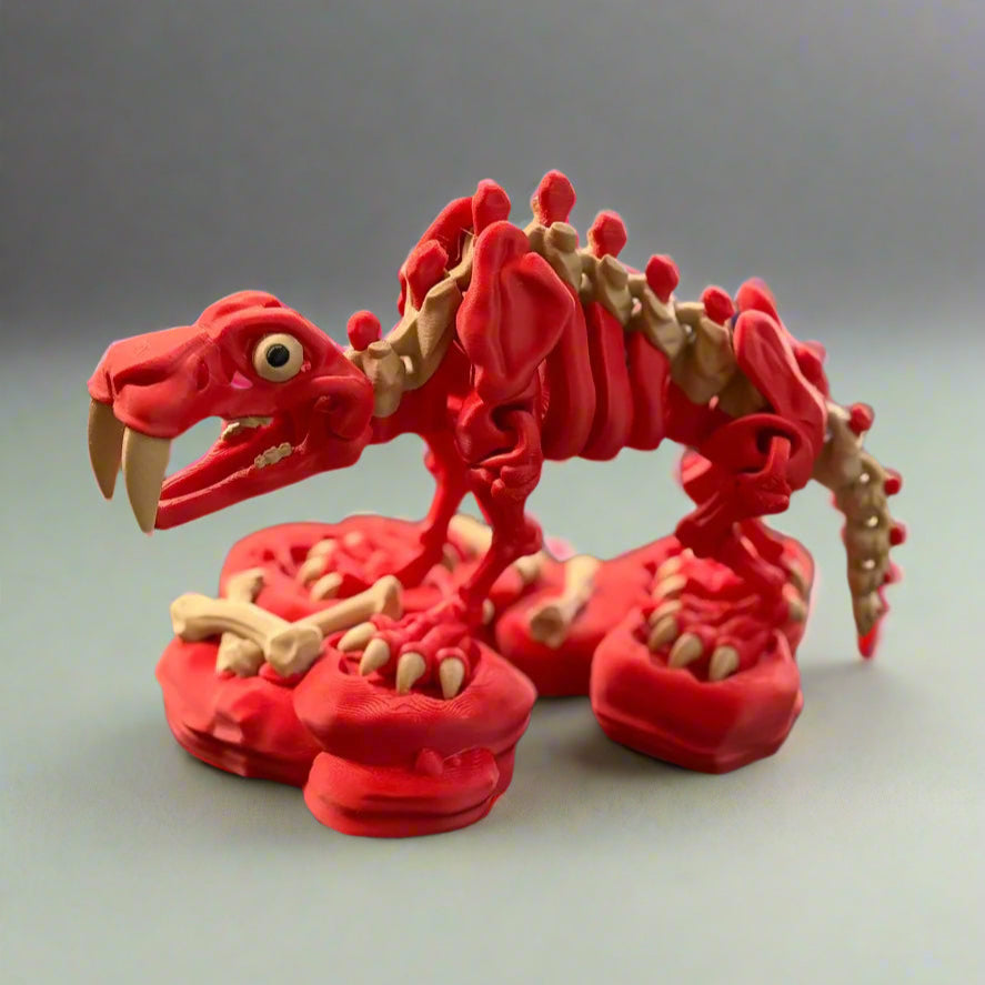 Red dinosaur skeleton model on a black surface with blurred background