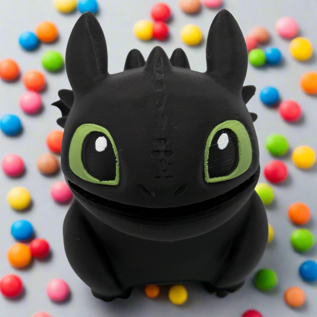 Black dragon toy with green eyes on a white background